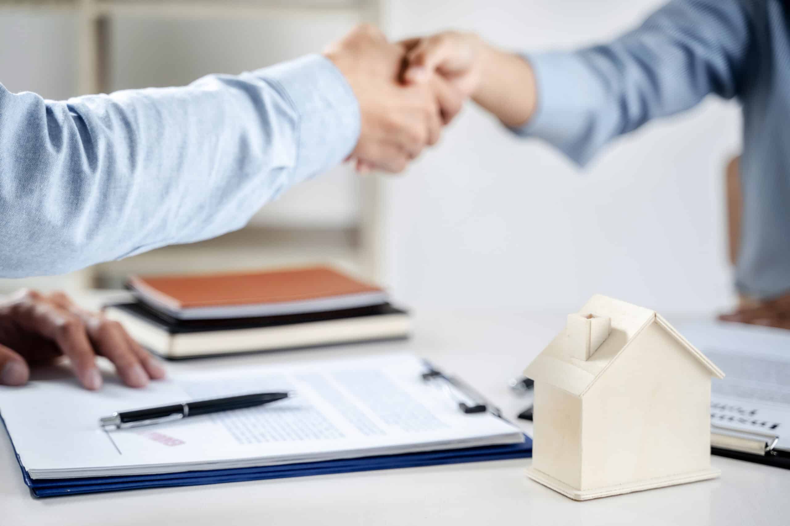 Business meeting Handshake. Home loan insurance. Real estate broker and client signing a contract insurance agreement document